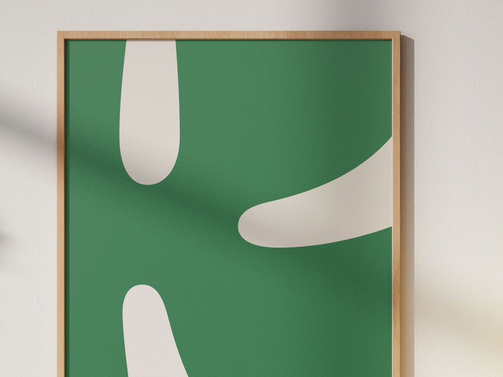 Postern Harmoni låter den typografiska formen möta en djup, grön ton som skapar lugn och balans.

Motivet bygger på samma bokstav som Kindlys signaturposter (bokstaven K), men står här som ett eget uttryck — mjukare, mer stilla och nära naturens färgskala.

Bokstaven är grön och bakgrunden vit, här är postern inramad och monterad på en vägg. Bilden är in-zoomad så det är bara halva som syns. 