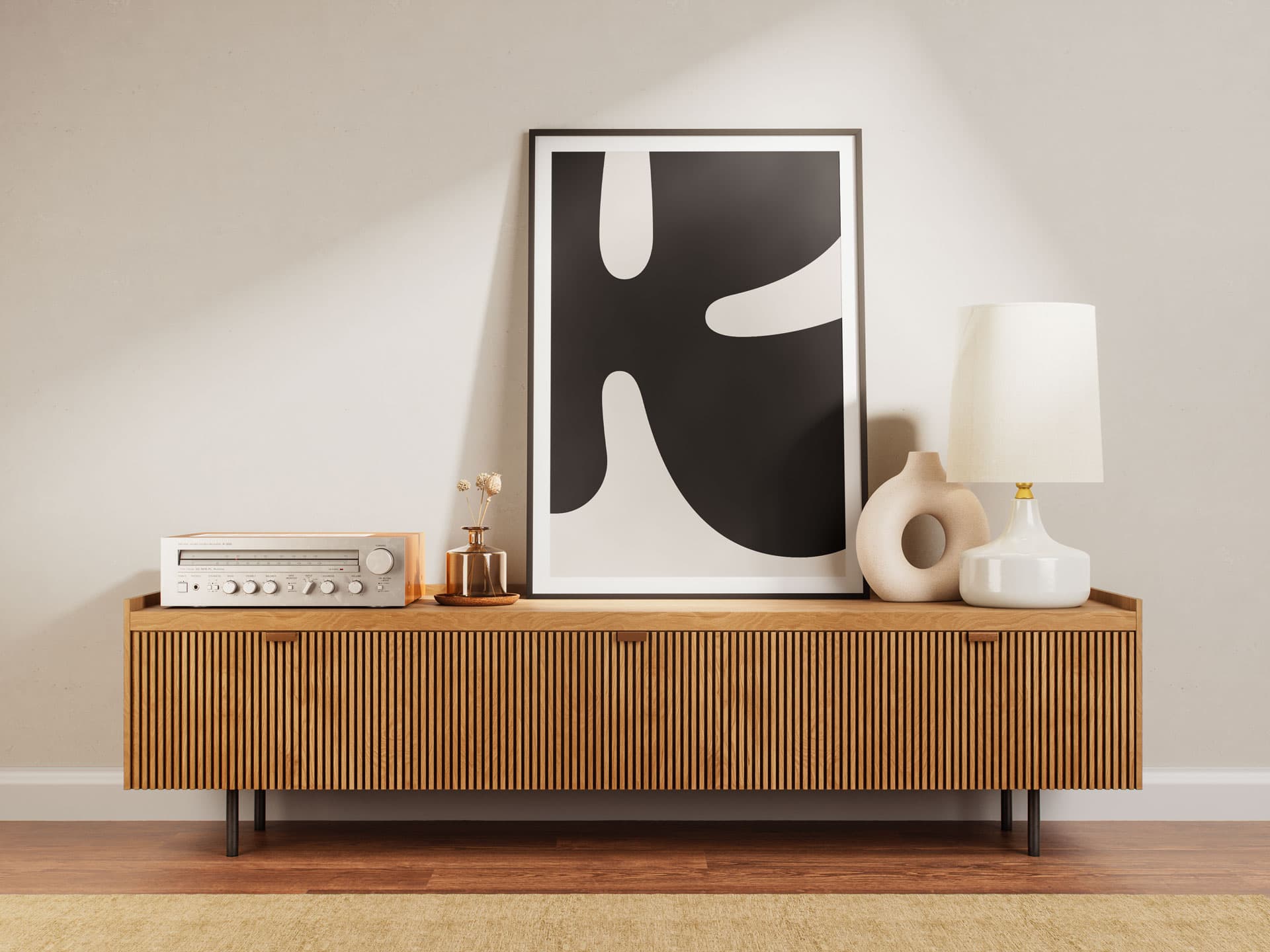 Postern visar upp vårt typografiska K från logotypen. Bokstaven är mörk och bakgrunden ljus. Här är postern inramad och lutad mot en vägg i ett hem. 