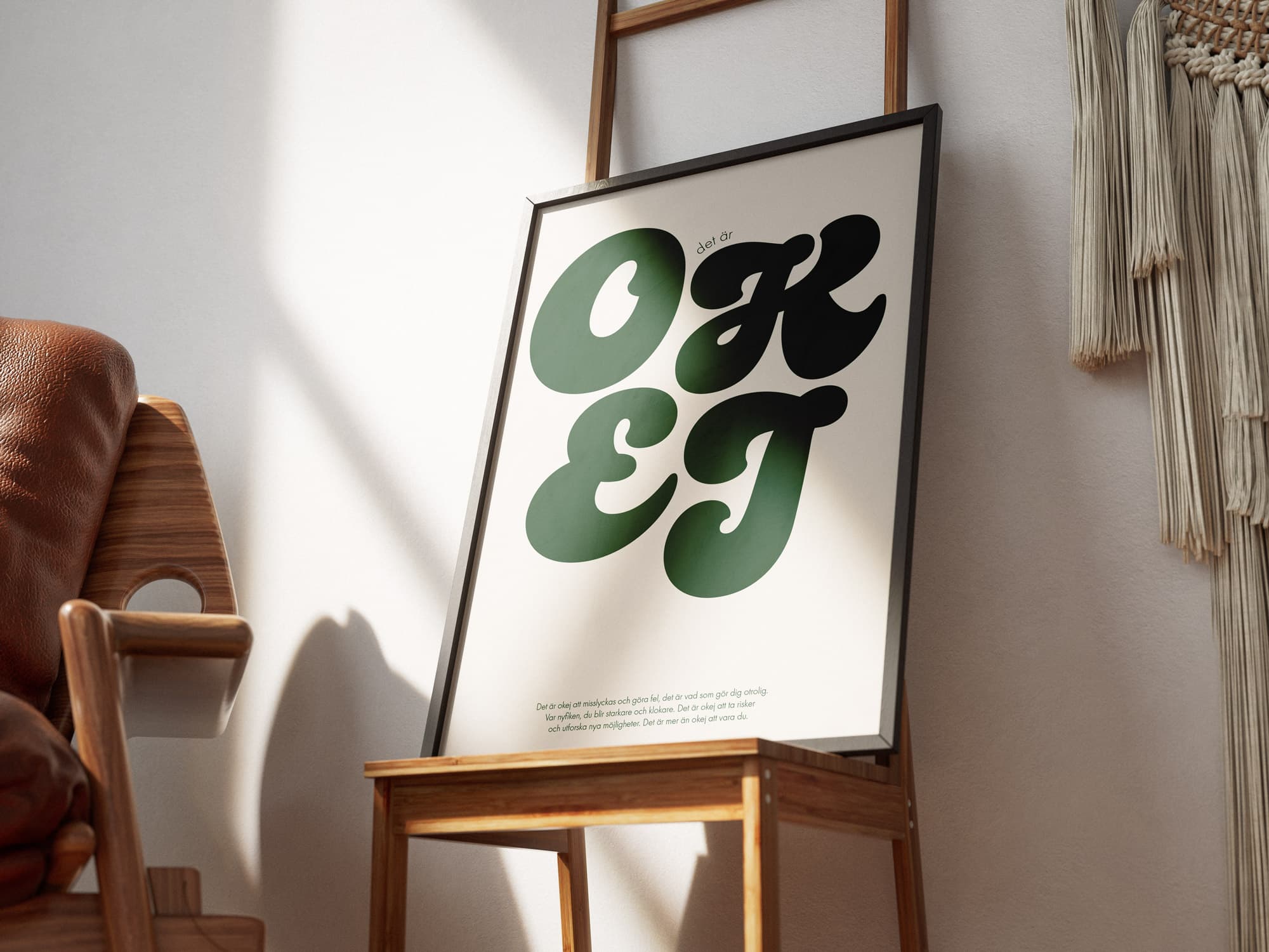 En typografisk poster med ordet OKEJ uppdraget stort i en grön nyans. Bakgrunden är vit och i botten finns en text som lyfter fram det som gör oss modiga: att prova, utforska och lära.
Motivet uppmuntrar till nyfikenhet och till att se möjligheter snarare än hinder — även när något inte blir som man tänkt.

Postern är här inramad och lutar mot en vägg.